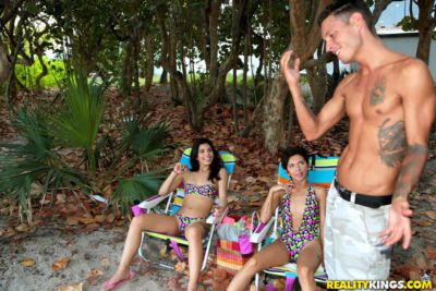 latina thiếu niên trong đồ bơi đưa chọn lên tại Bãi biển cho một Nóng nhóm ba
