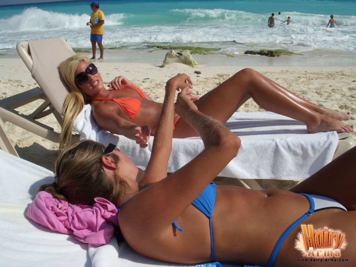 बालों से भरपूर सुनहरे बालों वाली लोरी एंडरसन आराम पर एक समुद्र तट में उसके बिकिनी और धूप का चश्मा