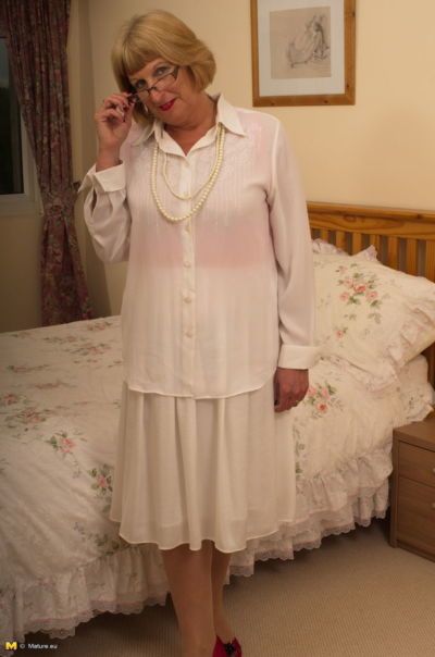 Horny old granny shyly removes her Sunday best to show her garter belt and ass
