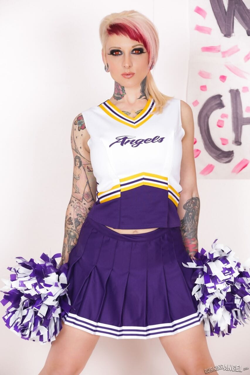 Tattooed chick Scarlet Lavey works free of a cheerleader outfit to pose naked
