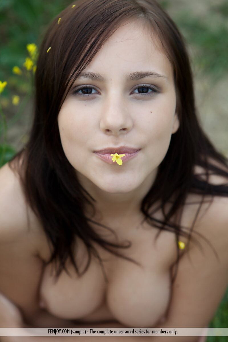 Naked girl Rosalin E plays with her boobs while walking in a field of mustard