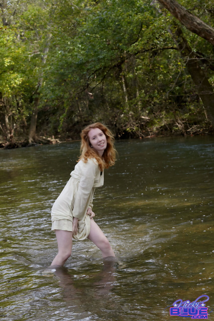 doğal kızıl saçlı Nicki MAVİ gösterir bazı bacak Süre wading içine bir sığ stream