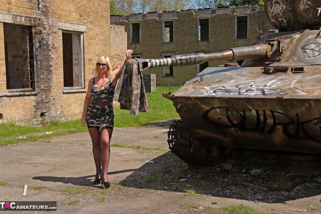 блондинка чик Мелодия удаляет ее камуфляж Платье в модель белье на а танк