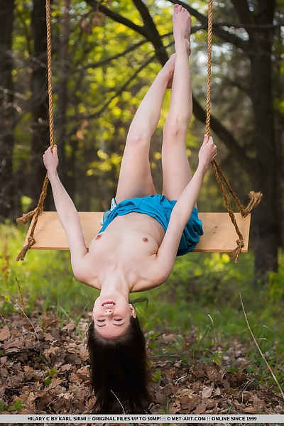 Young brunette Hilary C is encouraged to get naked on swing set in forest